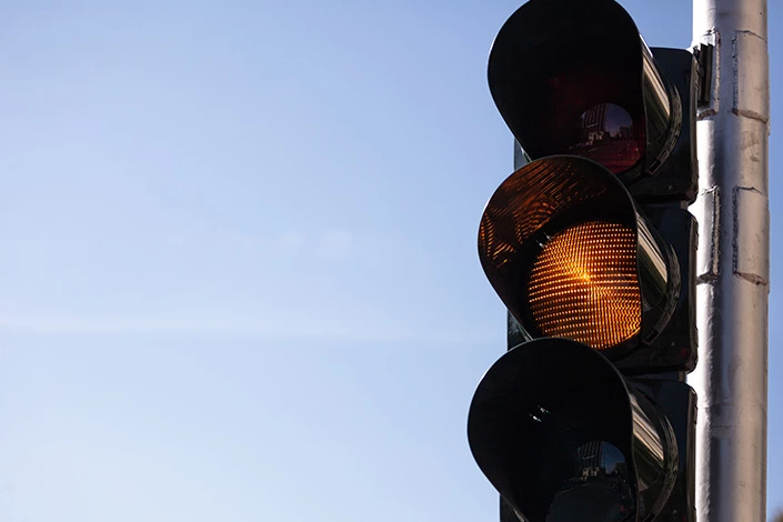 A yellow traffic light indicates that a failure to yield can cause a collision.